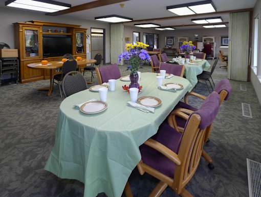 A dining room with a long table set for a meal.
